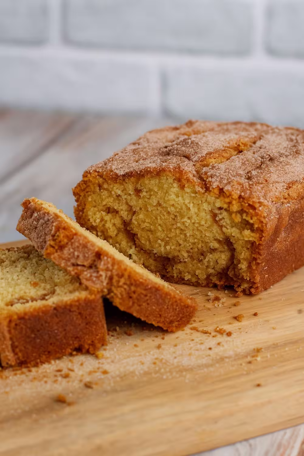Sliced loaf of homemade cinnamon Amish bread on a wooden cutting board.