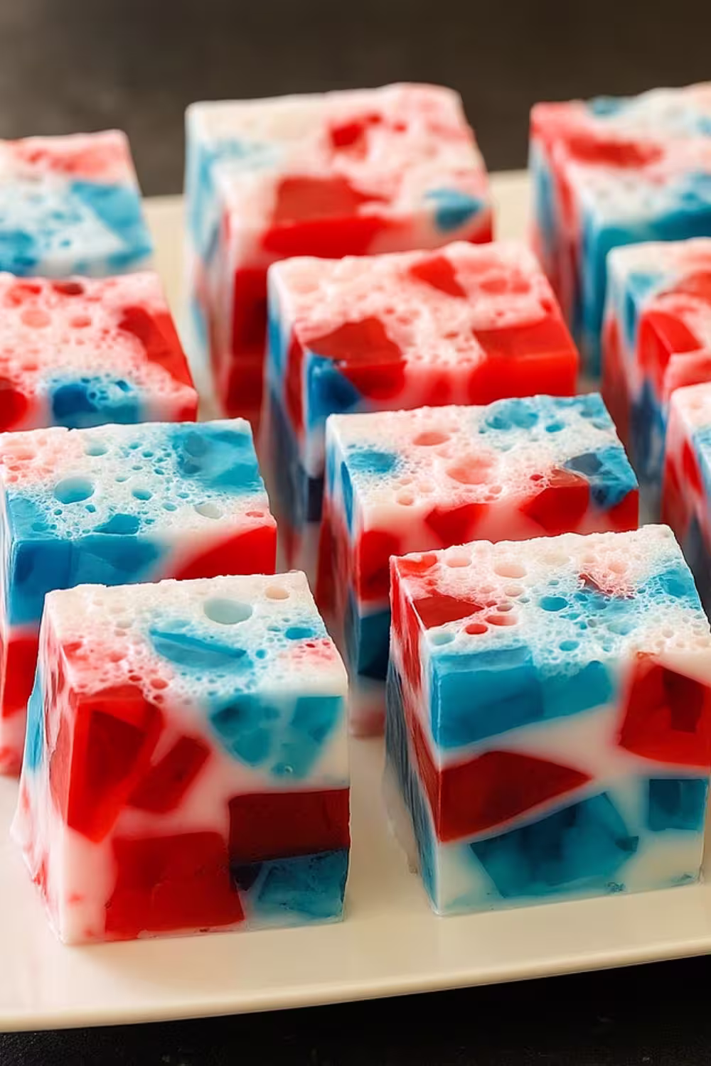 Cubes of festive 4th of July Jello in red, white, and blue on a serving plate