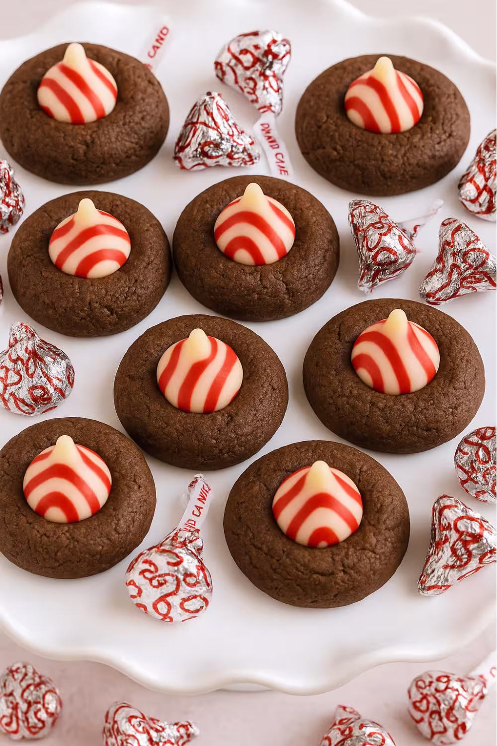 Festive peppermint chocolate thumbprint cookies topped with red and white Hershey’s candy cane kisses