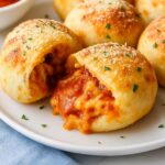 Air Fryer Pizza Bombs with melted cheese and pepperoni filling on a white plate
