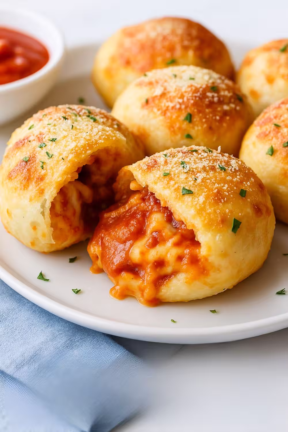 Air Fryer Pizza Bombs with melted cheese and pepperoni filling on a white plate