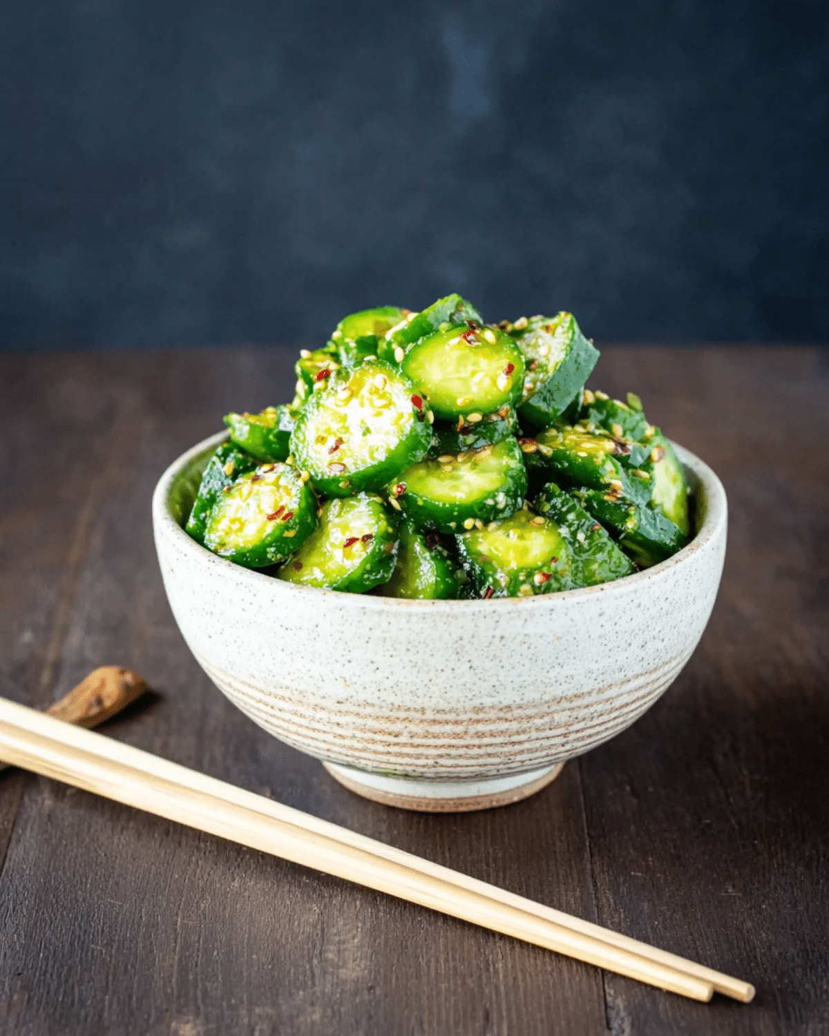 Bowl of TikTok Korean cucumber salad featuring sliced cucumbers tossed with sesame seeds, chili flakes, and seasonings.