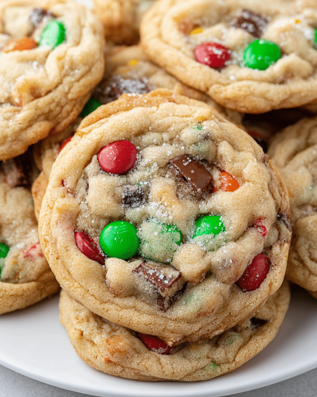 Christmas Kitchen Sink Cookies loaded with red and green candies, chocolate chunks, and sprinkled sugar on top.